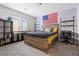 Bedroom showcasing a large wooden bed, decorative American flag, and open shelving, combining comfort and modern style at 4519 Stardusk Falls Ave, North Las Vegas, NV 89084