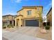 Two-story tan house with a brick driveway, stone accents, and a two-car garage at 4519 Stardusk Falls Ave, North Las Vegas, NV 89084