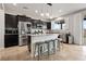 Contemporary kitchen with dark cabinetry, stainless steel appliances, island seating, and natural light at 4519 Stardusk Falls Ave, North Las Vegas, NV 89084