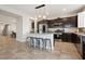Modern kitchen featuring a central island with seating, stainless steel appliances, and dark cabinets at 4519 Stardusk Falls Ave, North Las Vegas, NV 89084