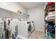 Efficient laundry room featuring modern washer and dryer, storage shelves, and cleaning supplies at 4519 Stardusk Falls Ave, North Las Vegas, NV 89084