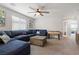 Cozy living room featuring a blue sectional sofa, coffee table, and plenty of natural light at 4519 Stardusk Falls Ave, North Las Vegas, NV 89084
