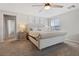 Spacious main bedroom features a tufted headboard, ceiling fan, and serene decor at 4519 Stardusk Falls Ave, North Las Vegas, NV 89084