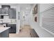 Hallway adjacent to kitchen with gray cabinets, stainless appliances, white countertop, and access to front entry at 4567 Chirping Cricket Ave, Las Vegas, NV 89141