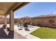 Inviting backyard with a covered patio, outdoor seating area, artificial turf, and a brick perimeter wall at 472 Cadence View Way, Henderson, NV 89011