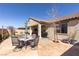Attractive backyard featuring a stone patio with outdoor seating, covered patio, and well-maintained landscaping at 472 Cadence View Way, Henderson, NV 89011