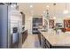 Modern kitchen with a stainless steel refrigerator, granite countertops, and a view into the adjacent living area at 472 Cadence View Way, Henderson, NV 89011