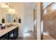 Bathroom featuring double sinks, large mirrors, a walk-in shower, and neutral paint at 472 Cadence View Way, Henderson, NV 89011