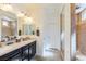 Bathroom with double sinks, large mirrors, a walk-in shower, and neutral paint at 472 Cadence View Way, Henderson, NV 89011