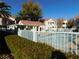 Community pool surrounded by a fence and greenery with desert landscaping at 4855 S Torrey Pines Dr # 102, Las Vegas, NV 89103