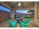 Inviting outdoor patio with seating offers a stunning view of the pool, landscaped yard, and desert landscape beyond at 51 Reflection Cove Dr, Henderson, NV 89011