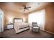 Relaxing main bedroom featuring natural light, a ceiling fan, and a comfortable recliner at 5863 Corbin Ave, Las Vegas, NV 89122
