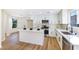 Bright kitchen with white cabinets, island, stainless steel appliances and wood-look floors at 6628 Silver Penny Ave, Las Vegas, NV 89108