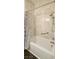 Bathroom featuring shower and tub combo, neutral tile, safety bar, and shower curtain at 7858 Nookfield Dr, Las Vegas, NV 89147