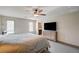 A bedroom with a ceiling fan, dresser, large window, and view into the ensuite bathroom at 8087 Carpenter Creek Ave, Las Vegas, NV 89113