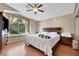 This bedroom features hardwood floors, a ceiling fan, and a quaint window seat overlooking the backyard at 8427 Green Mesa Ct, Las Vegas, NV 89147