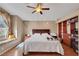 Well-lit bedroom featuring hardwood floors, ceiling fan, and a comfortable window seat at 8427 Green Mesa Ct, Las Vegas, NV 89147