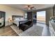 Bright bedroom featuring dark wood floors, ceiling fan, balcony access, and large patterned rug at 8834 Sherborne Gate Ave, Las Vegas, NV 89148