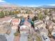 Aerial view of neighborhood with mountain backdrop, pools, solar panels, and mature trees at 9836 La Vid Ct, Las Vegas, NV 89117