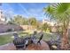 Inviting backyard with manicured lawn, seating area, and mature landscaping under a blue sky at 9836 La Vid Ct, Las Vegas, NV 89117