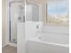Clean and well-lit bathroom with a glass-enclosed shower, soaking tub, and window at 9836 La Vid Ct, Las Vegas, NV 89117