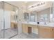 Bright bathroom featuring double sinks, vanity mirrors, and neutral tile flooring at 9836 La Vid Ct, Las Vegas, NV 89117