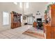 Bright living room with tile floors, large windows, and a dedicated workspace with built-in shelving at 9836 La Vid Ct, Las Vegas, NV 89117