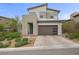 Beautifully landscaped two-story home with a modern exterior, manicured yard, and brick paved driveway at 11991 Rockview Point St, Las Vegas, NV 89138