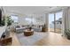 Stylish living room boasts a gray sectional sofa, round wood coffee table, and sliding glass doors to the patio at 11991 Rockview Point St, Las Vegas, NV 89138