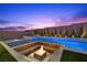 The sparkling pool features a sunken firepit, built in spa, and is surrounded by desert landscaping at 11991 Rockview Point St, Las Vegas, NV 89138