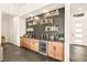 Elegant bar area showcasing open shelving, a sink, beverage cooler, and wooden cabinetry at 12103 Canyon Sunset St, Las Vegas, NV 89138