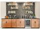 Well-stocked bar area with wooden cabinets, open shelving, and a beverage refrigerator at 12103 Canyon Sunset St, Las Vegas, NV 89138