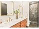 Modern bathroom with double sinks, quartz counters, wood cabinets, and a marble tile shower at 12103 Canyon Sunset St, Las Vegas, NV 89138