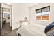 Light-filled bedroom with a large window, light walls, and gray tile flooring at 12103 Canyon Sunset St, Las Vegas, NV 89138