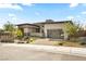 Modern home with a well-manicured front yard, a stone facade, and a glass garage door at 12103 Canyon Sunset St, Las Vegas, NV 89138