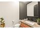 Chic powder room with a decorative mirror, sleek black faucet, and herringbone tile accent wall at 12103 Canyon Sunset St, Las Vegas, NV 89138