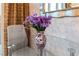 Elegant dining table with a mirrored vase full of purple flowers at 125 E Harmon Ave # 216, Las Vegas, NV 89109