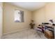 This bedroom has a neutral carpet and a window, and a small desk and shelf provide working space at 214 Roxborough St, Henderson, NV 89074