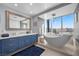 Elegant bathroom with a modern tub, blue vanity, and a large window offering stunning city views at 2700 Las Vegas Blvd # 809, Las Vegas, NV 89109