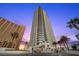 High-rise building featuring multiple balconies against a twilight sky with lush palm trees at 2700 Las Vegas Blvd # 809, Las Vegas, NV 89109