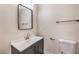 Bathroom with a single sink vanity, white countertops, a steel framed mirror, and black hardware at 3314 El Camino Real, Las Vegas, NV 89121