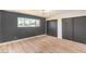 Bedroom with wood flooring, accent wall, large window, modern light fixture, and built-in closets at 3314 El Camino Real, Las Vegas, NV 89121