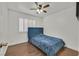 Cozy bedroom features wood floors, a ceiling fan, and a blue bed with a tufted headboard at 3514 Jordan Ln, North Las Vegas, NV 89032