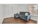 Cozy bedroom featuring hardwood floors, a window with blinds, and a gray sofa at 3514 Jordan Ln, North Las Vegas, NV 89032