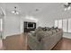 Bright living room with a large gray sofa, modern built-ins, and hardwood floors at 3514 Jordan Ln, North Las Vegas, NV 89032