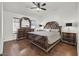 Comfortable main bedroom with hardwood floors, a ceiling fan, window, and a large, ornate bed set at 3514 Jordan Ln, North Las Vegas, NV 89032