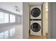 Bright living room featuring ceramic tile floors, a ceiling fan, and a stackable washer and dryer in an alcove at 3966 Torsby Pl, Las Vegas, NV 89119