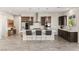 Modern eat-in kitchen with white countertop, stainless steel appliances, tile backsplash, and dark wood cabinets at 4081 Turquoise Falls St, Las Vegas, NV 89129