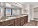 Bathroom featuring dual sinks, a granite countertop, wood look flooring, and ample lighting at 4116 Free Bird Crest Ave, North Las Vegas, NV 89081