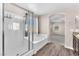 Elegant bathroom showcasing a soaking tub with glass enclosure, and a view of the carpeted bedroom at 4116 Free Bird Crest Ave, North Las Vegas, NV 89081